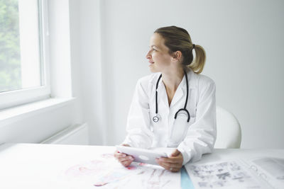 Smiling doctor with digital tablet at clinic