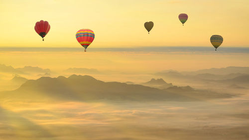 Hot air balloons flying against sky during sunset