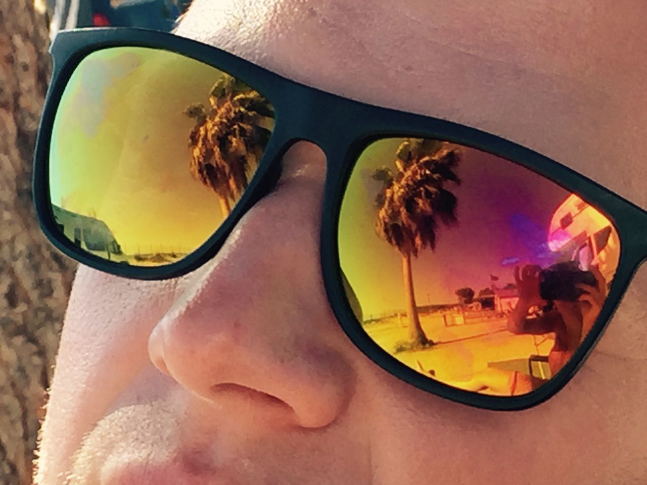 REFLECTION OF MAN PHOTOGRAPHING SUNGLASSES