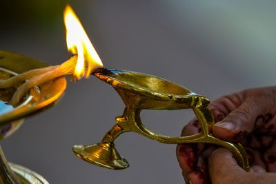 Cropped hand of woman igniting diya