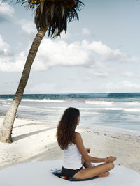 Young woman meditation on beach