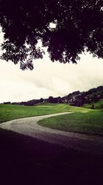 Scenic view of grassy field against cloudy sky