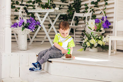 Full length of boy sitting on purple floor