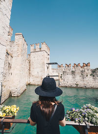 Rear view of woman looking at castle against clear sky