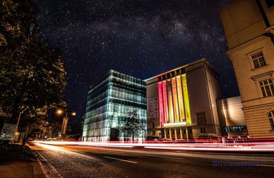 Light trails on road against sky at night