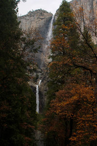 Scenic view of waterfall against sky during autumn