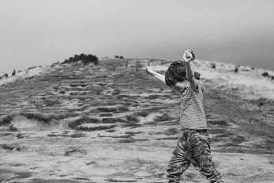 Rear view of man walking on beach