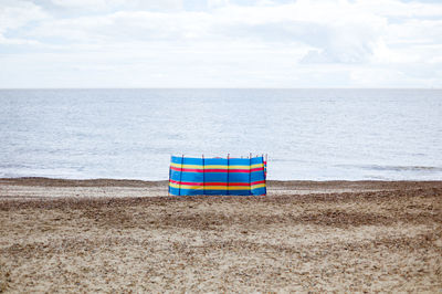 Lifeguard hut on beach against sky