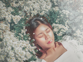 Portrait of beautiful woman by flower plants