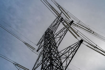 Low angle view of electricity pylon against sky