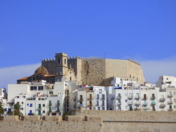 High section of built structures against blue sky