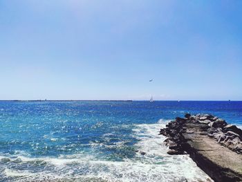 Scenic view of sea against clear blue sky