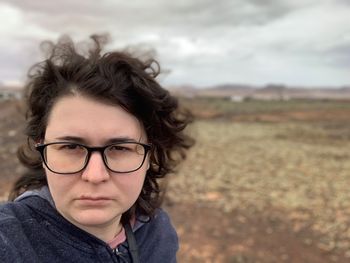 Close-up portrait of woman standing on field 