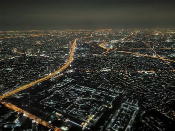 Aerial view of illuminated buildings in city at night