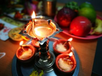 Close-up of illuminated diya on table