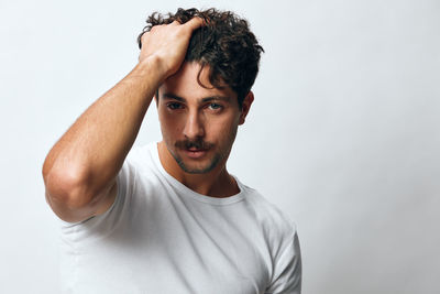 Young man looking away against white background