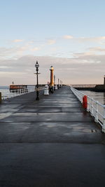 Pier amidst sea against sky during sunset