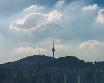 Buildings in city against cloudy sky