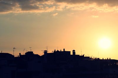 Silhouette city against sky during sunset