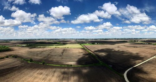 Road by field against sky