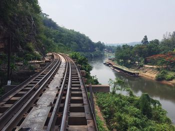 High angle view of railroad tracks by river against sky