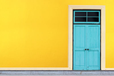 Closed blue doors of yellow building