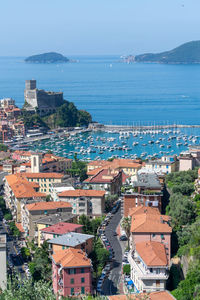 High angle view of townscape by sea against clear sky