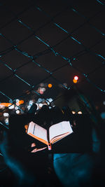 High angle view of woman holding book at night