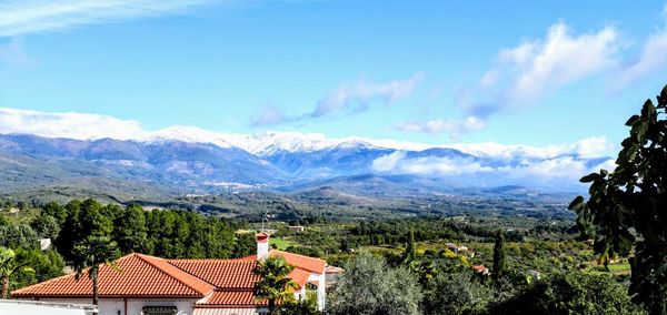 Panoramic view of houses and mountains against sky