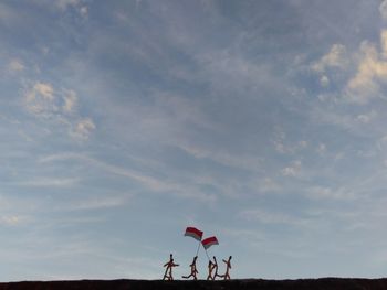 People standing at beach against sky