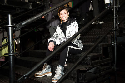 Portrait of smiling woman standing on staircase