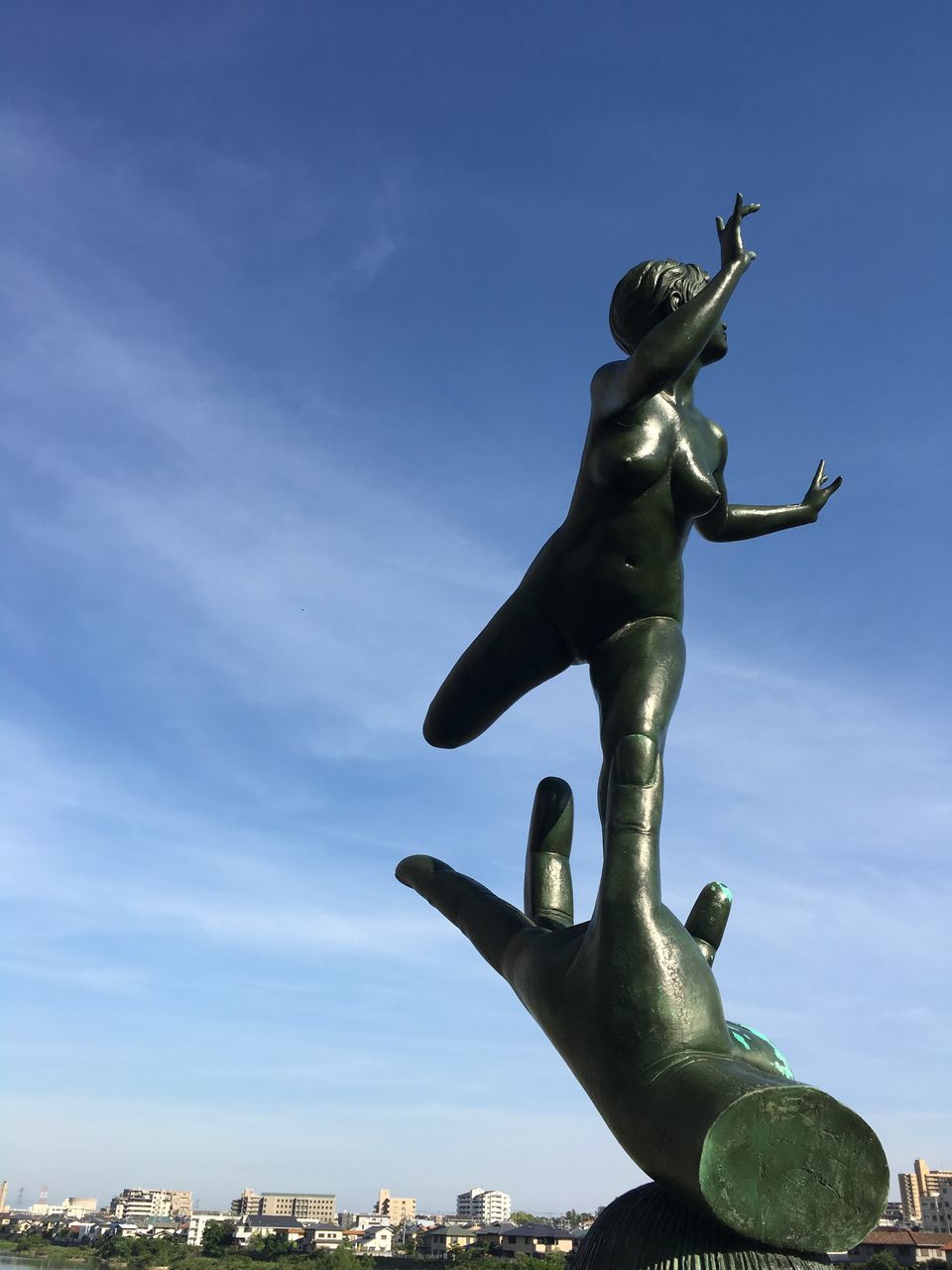 LOW ANGLE VIEW OF STATUE AGAINST CITYSCAPE