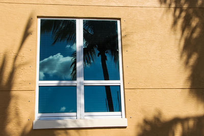 Low angle view of glass window on building wall