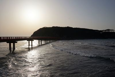 Bridge over sea against clear sky