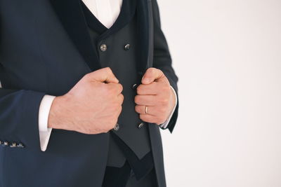 Midsection of businessman standing against white background