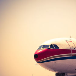 Airplane flying against sky during sunset