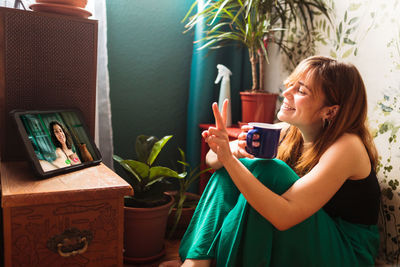 Young woman looking at camera while sitting at home