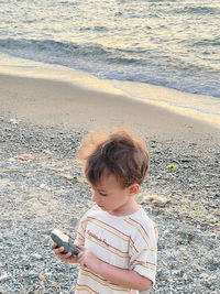 High angle view of boy standing at beach