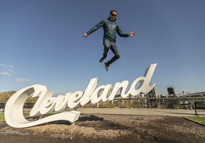 Man in down jacket leaps jumps of cleveland sign, ohio