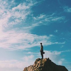 Low angle view of man standing on rock