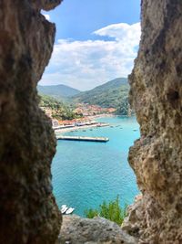 Scenic view of sea by mountains against sky