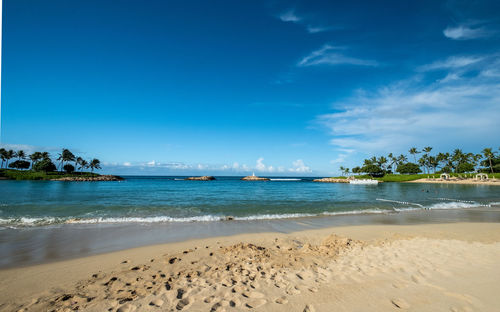 Scenic view of beach against blue sky