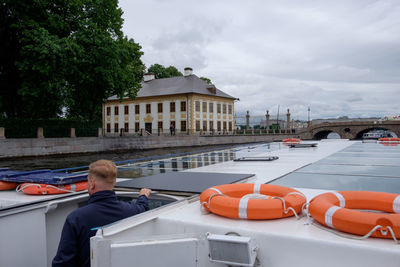 Rear view of man in boat against sky