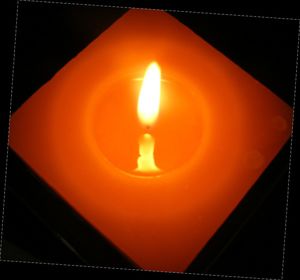 Close-up of lit candle in dark room