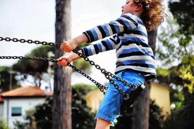 Side view of boy on swing