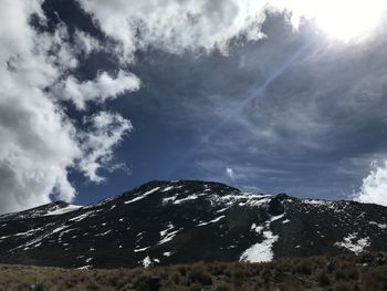Low angle view of snowcapped mountain against sky