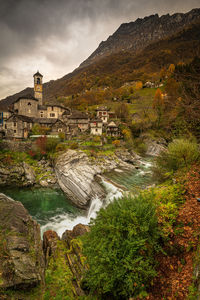 Scenic view of river amidst buildings against sky