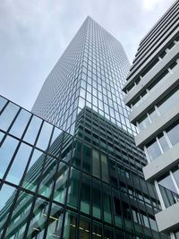 Low angle view of modern glass building against sky