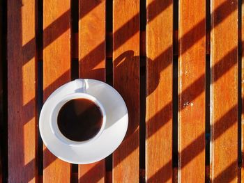 High angle view of coffee in white cup on wooden table