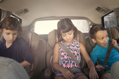 Front view of siblings sitting in car